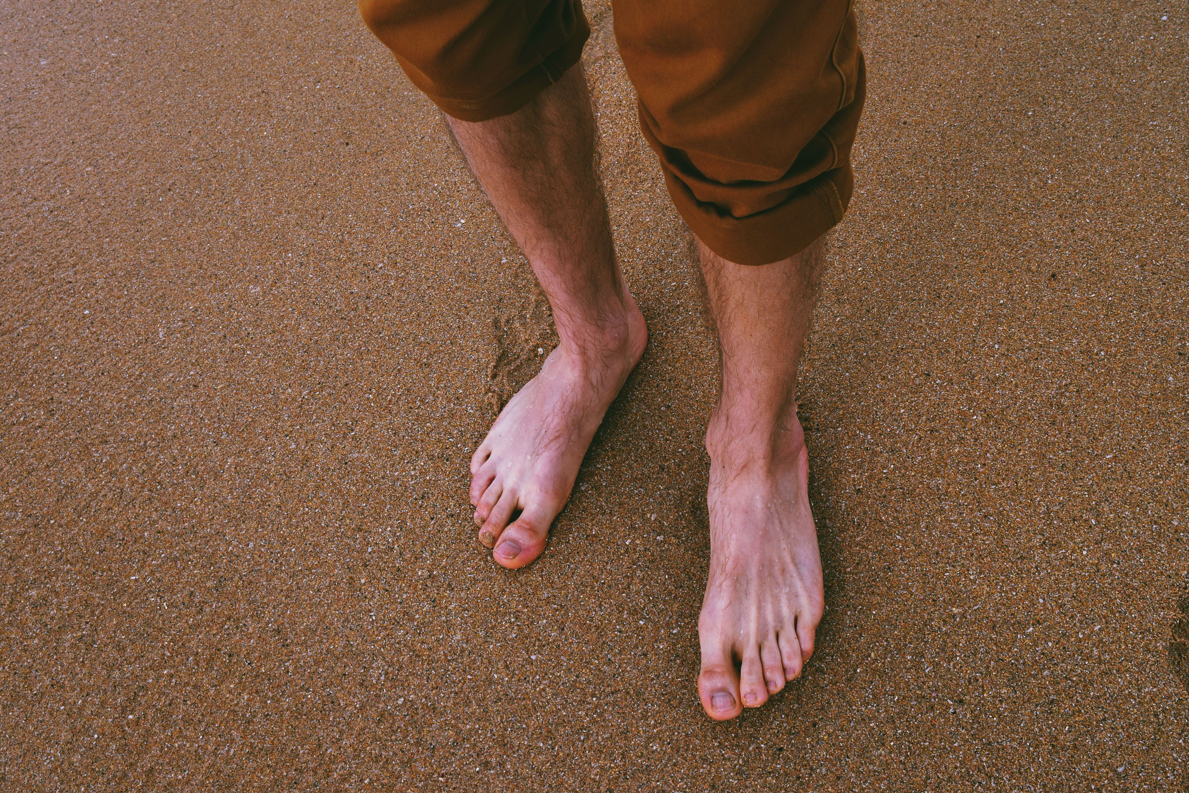 Mens feet on a sandy beach